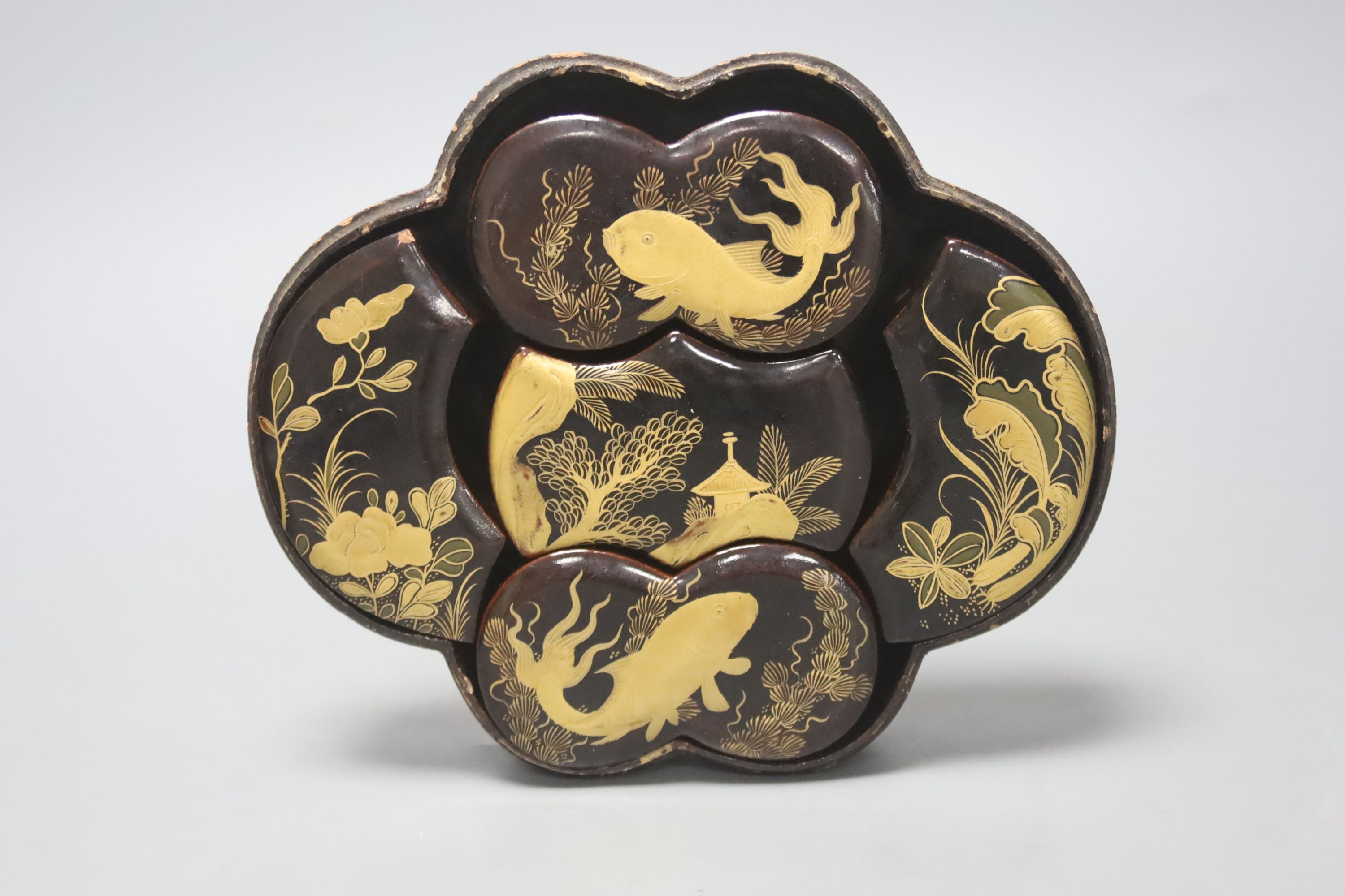 A Japanese black-lacquered box and cover, of shaped oval form, the top decorated in red and gilt with a stork on a branch, prunus, etc, L 16.5cm